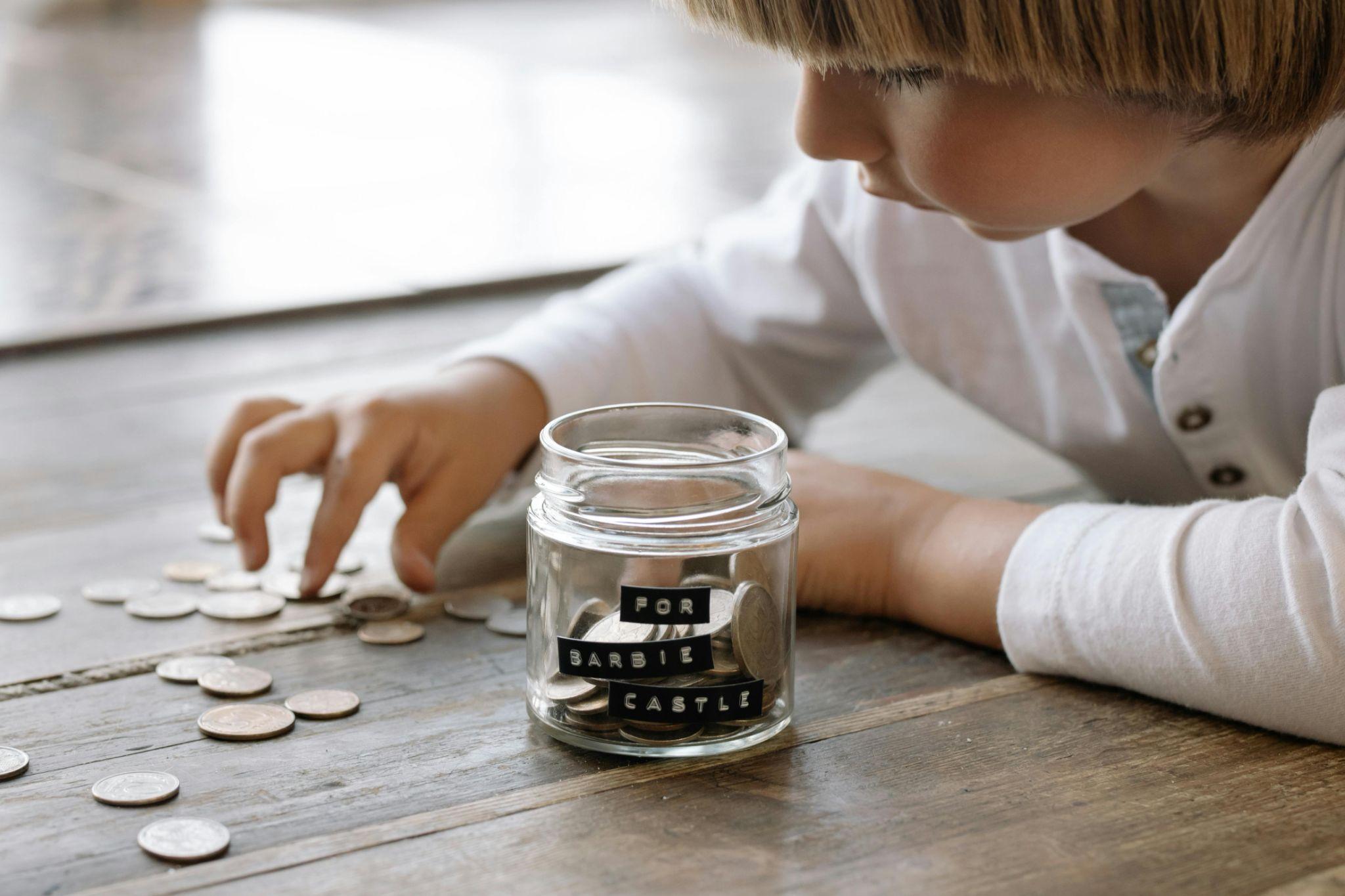 Kid saving change in a jar.