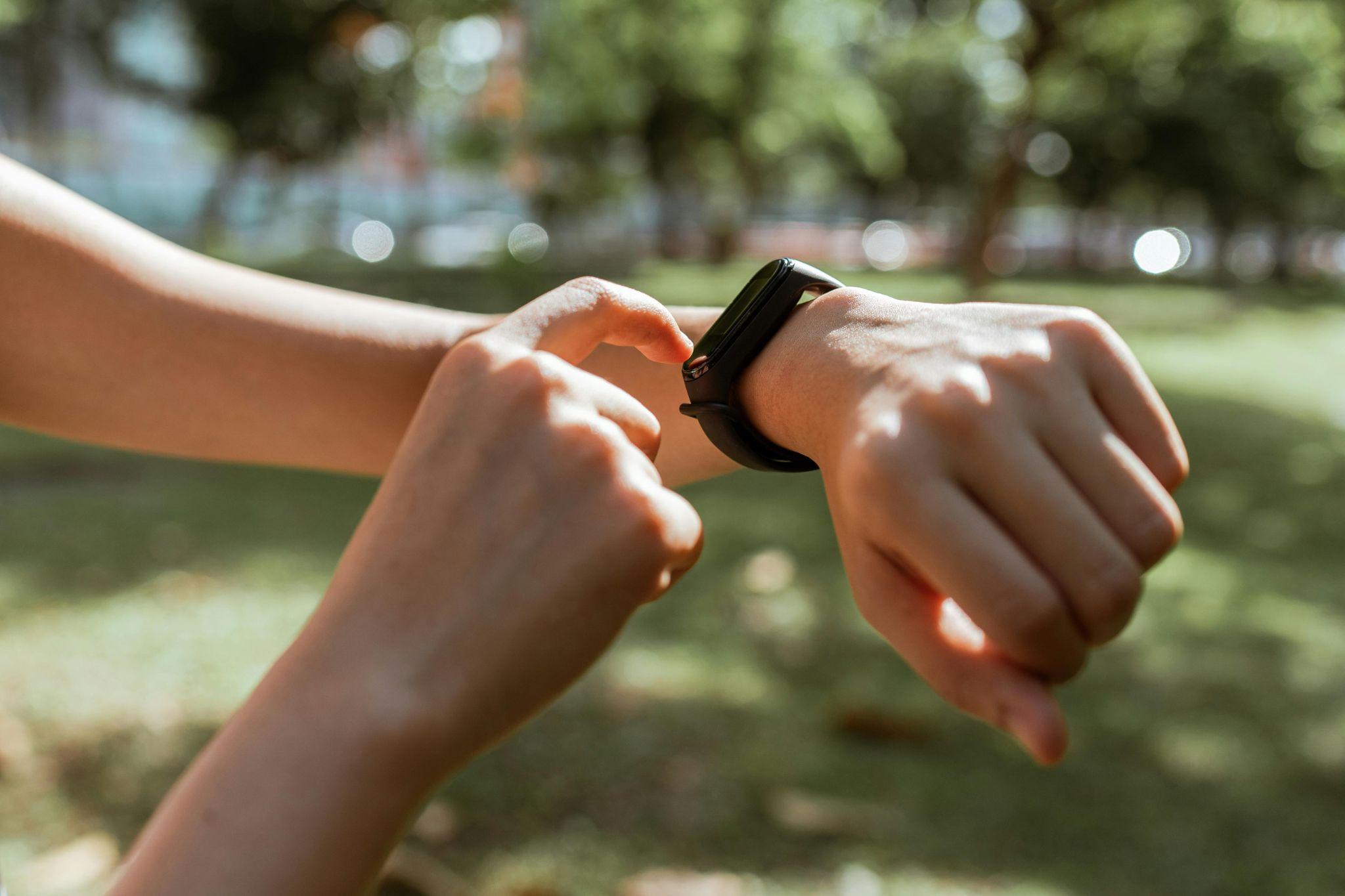 Teenager checking fitness tracker.